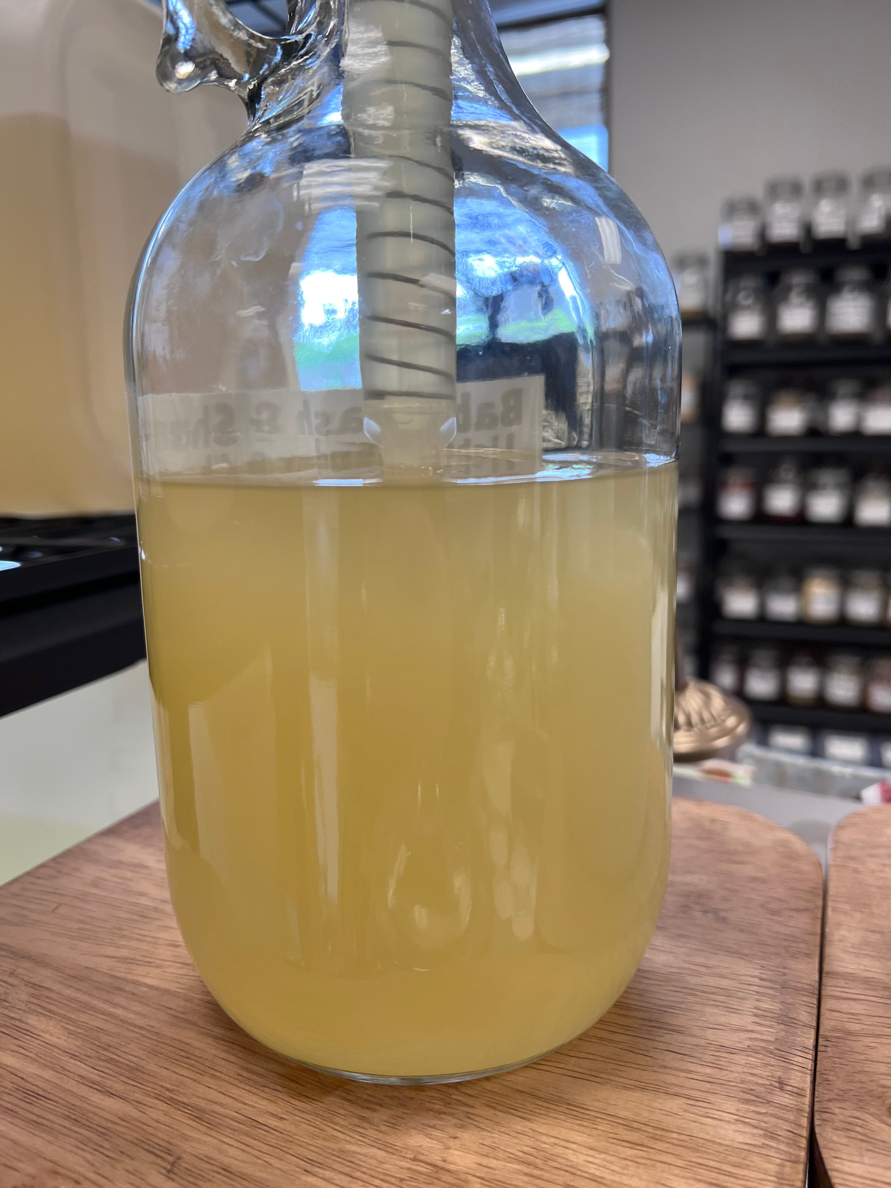Clear bottle with cream colored soap on a wooden surface