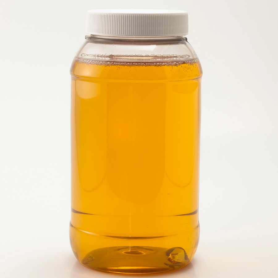 Jar of blue agave syrup with a white lid on a white background