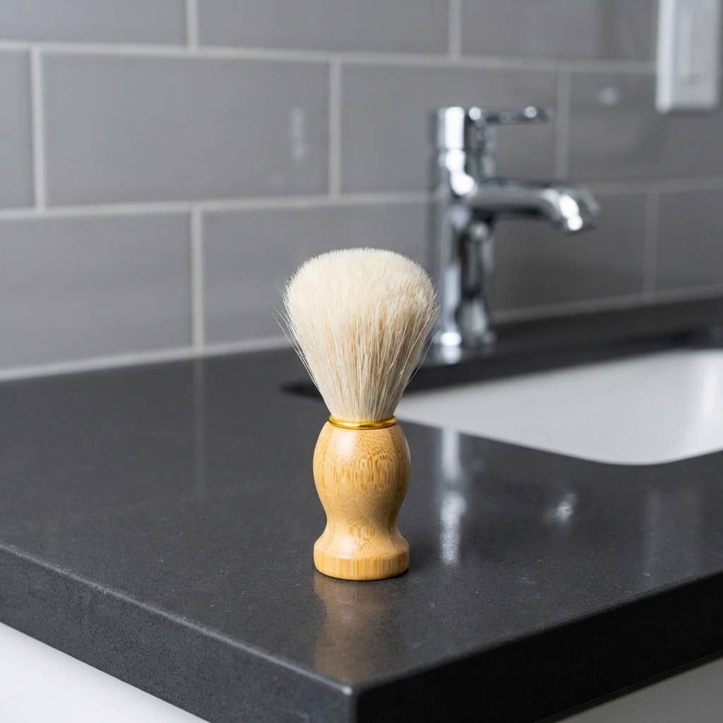 Shaving brush on a bathroom counter with a sink and faucet in the background