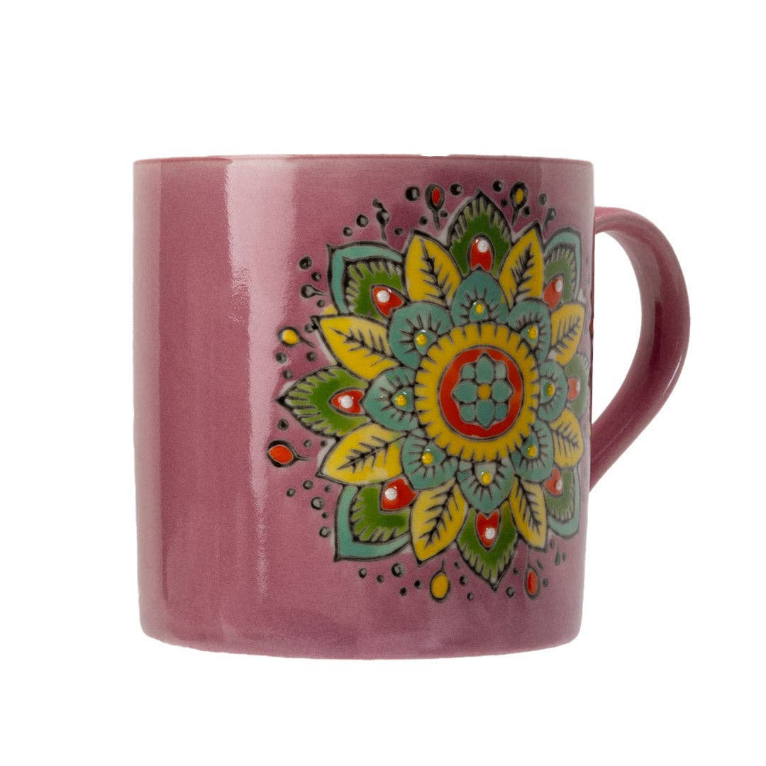 Pink mug with a colorful mandala design on a white background