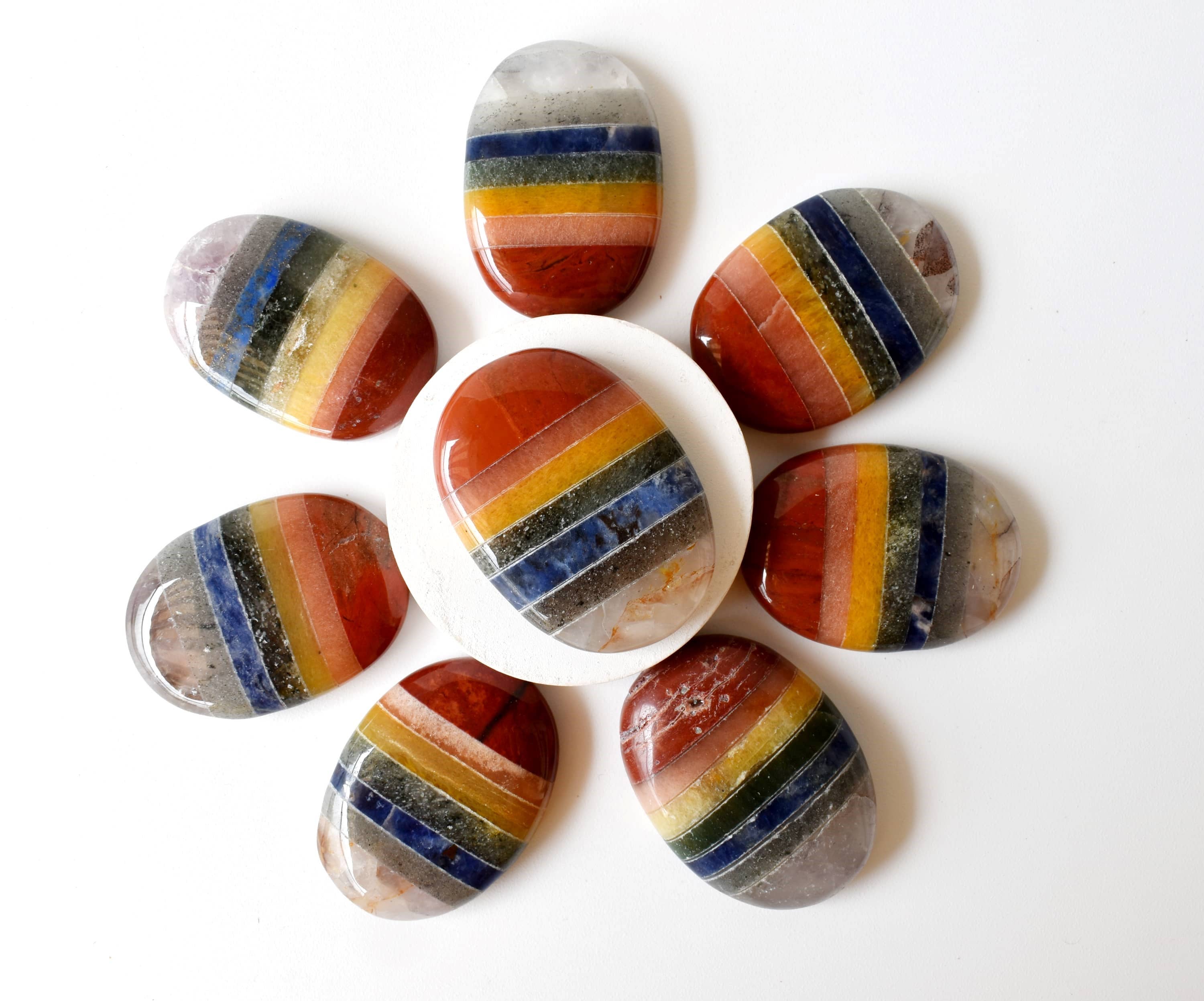 Set of rainbow-striped stones on a white background