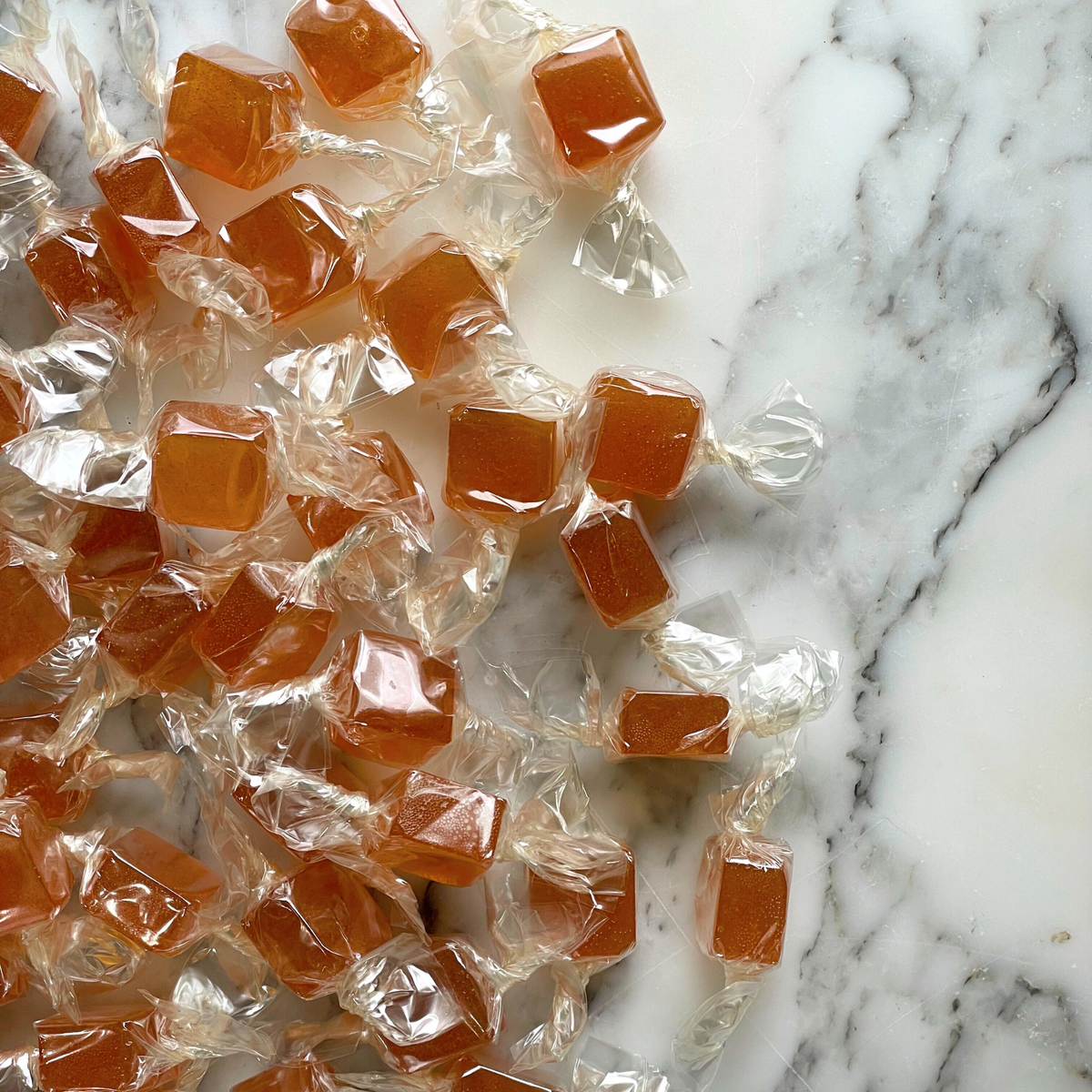 Candies in clear wrappers on a marble surface