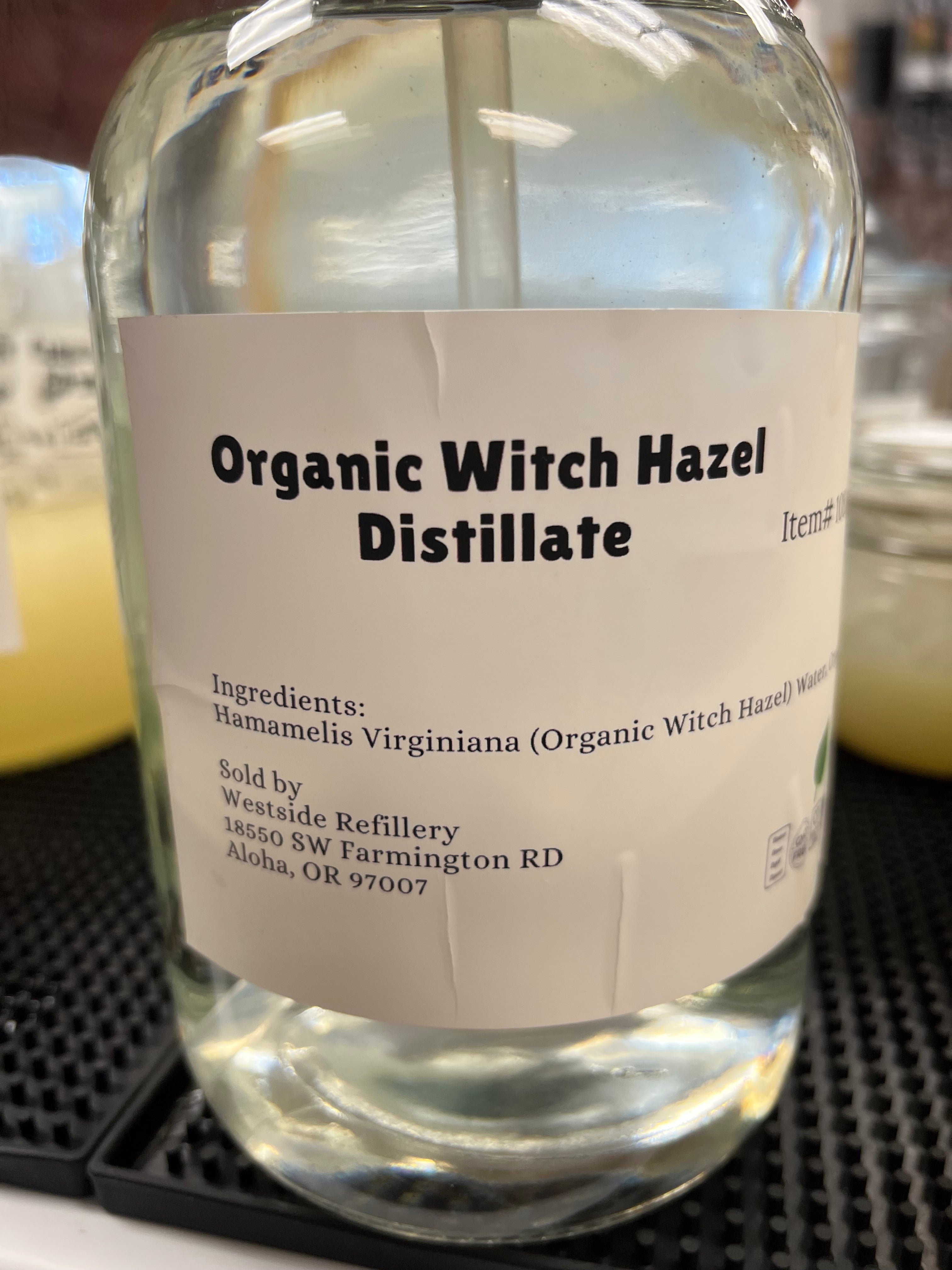 Bottle of Organic Witch Hazel Distillate with a label on a blurred background