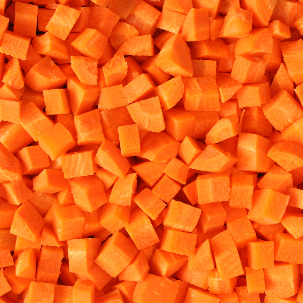 A close-up, top-down view of diced orange carrots filling the entire frame.