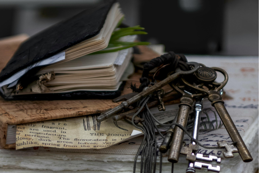 Vintage keys and open book on a textured surface
