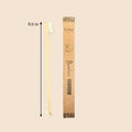 Bamboo toothbrush with packaging and measurement label on a beige background