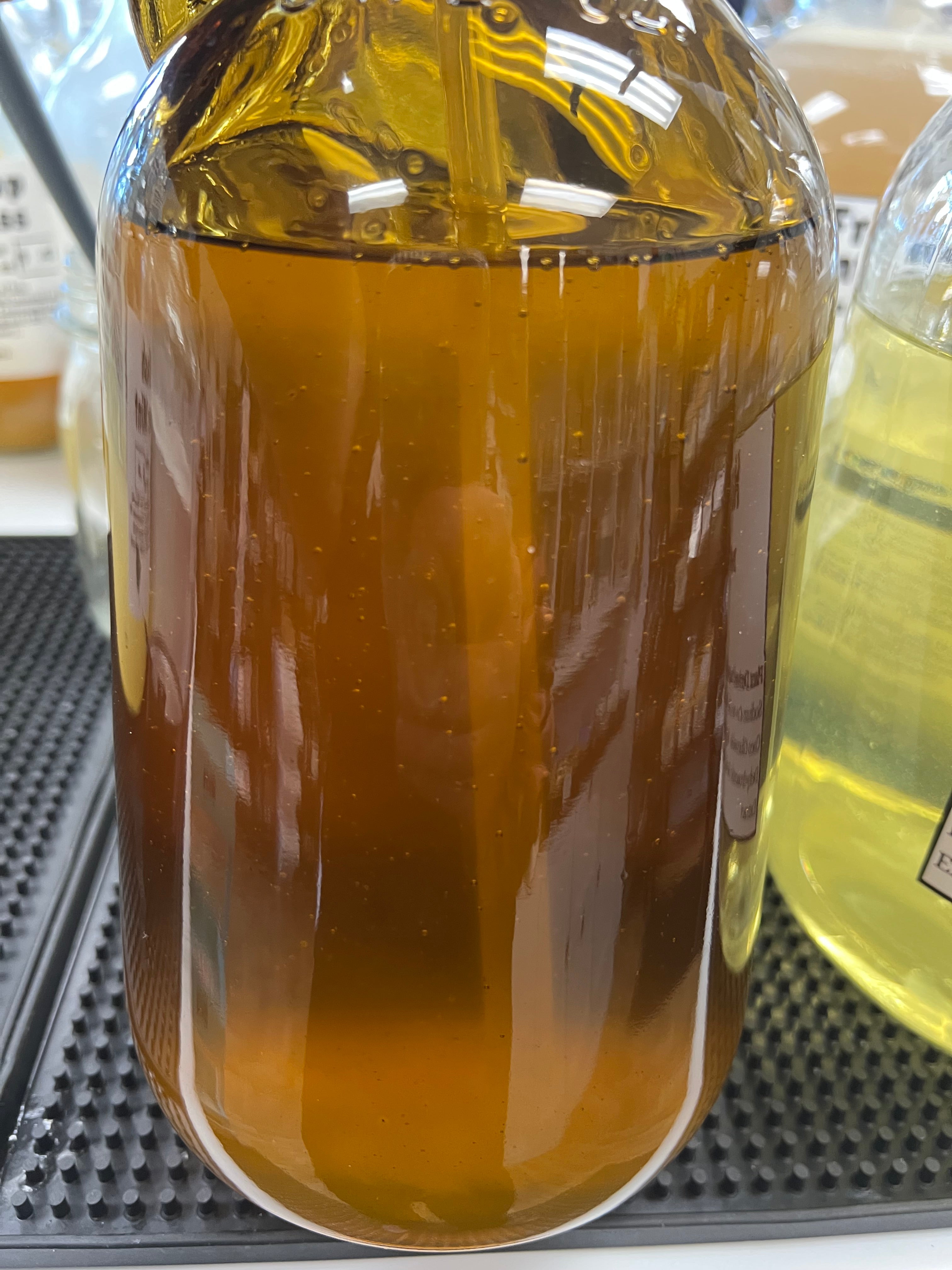 Glass container filled with oil on a textured surface