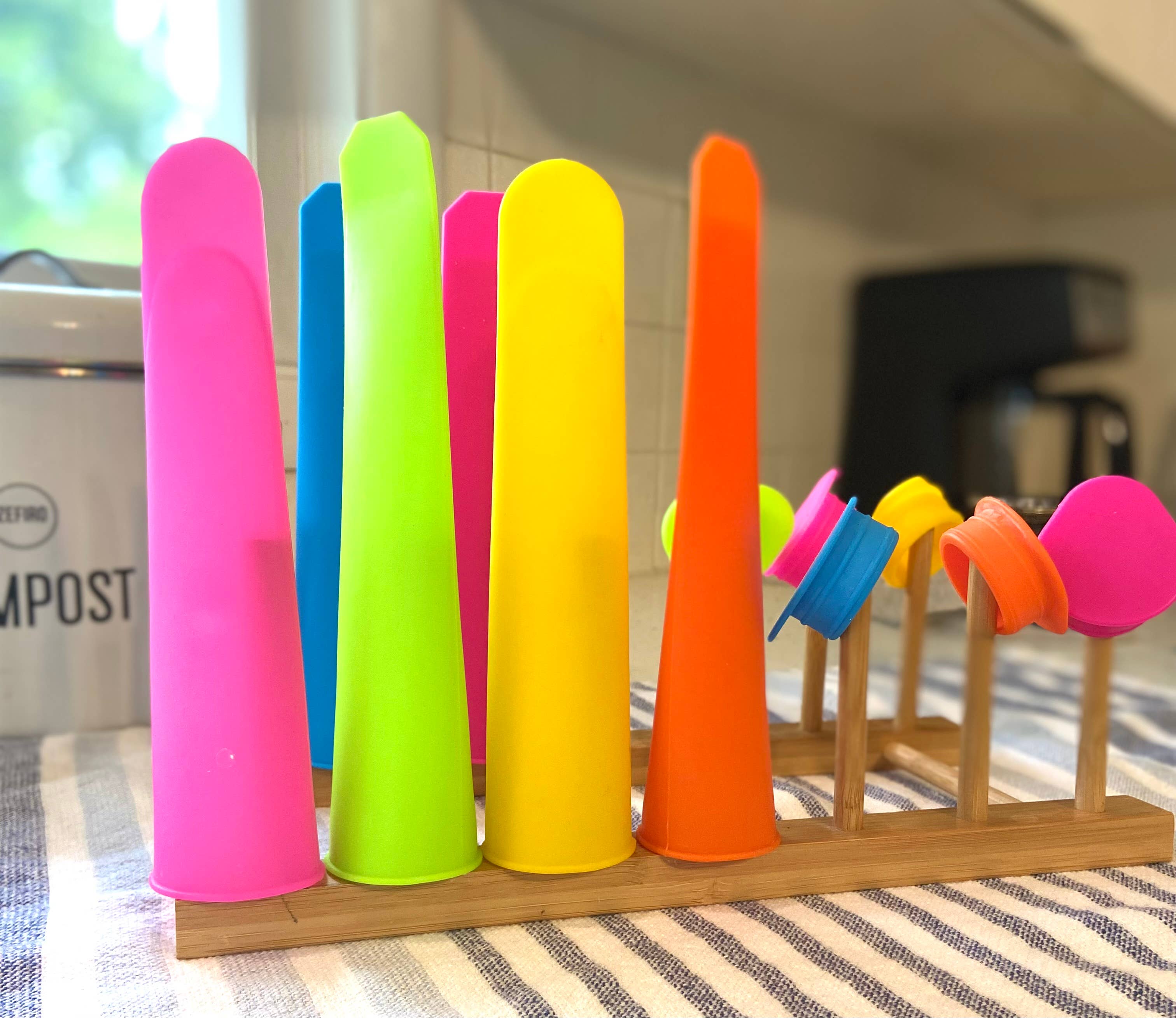 Colorful push pop silicone molds on a wooden stand with a blurred background