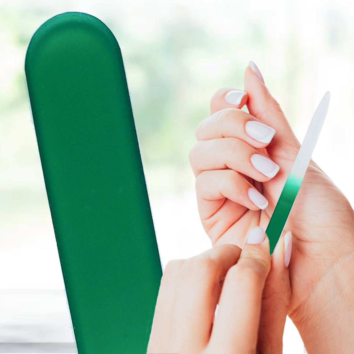 Person filing nails with a green glass nail file on a blurred natural background