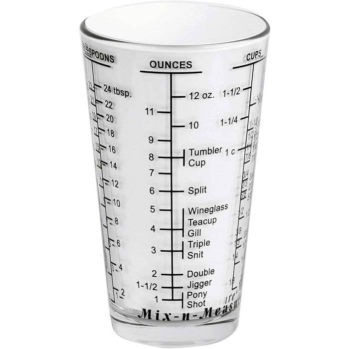 Clear measuring glass with volume markings on a white background