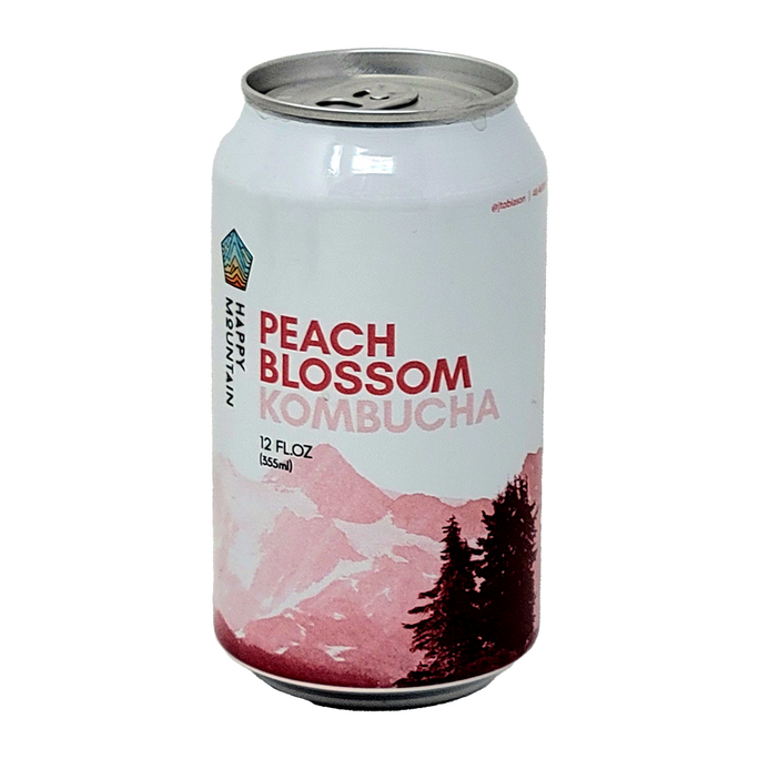 A 12 fl oz can of Happy Mountain Kombucha in the Peach Blossom flavor, featuring a white and pink mountain design with pine trees on the label, set against a plain white background.