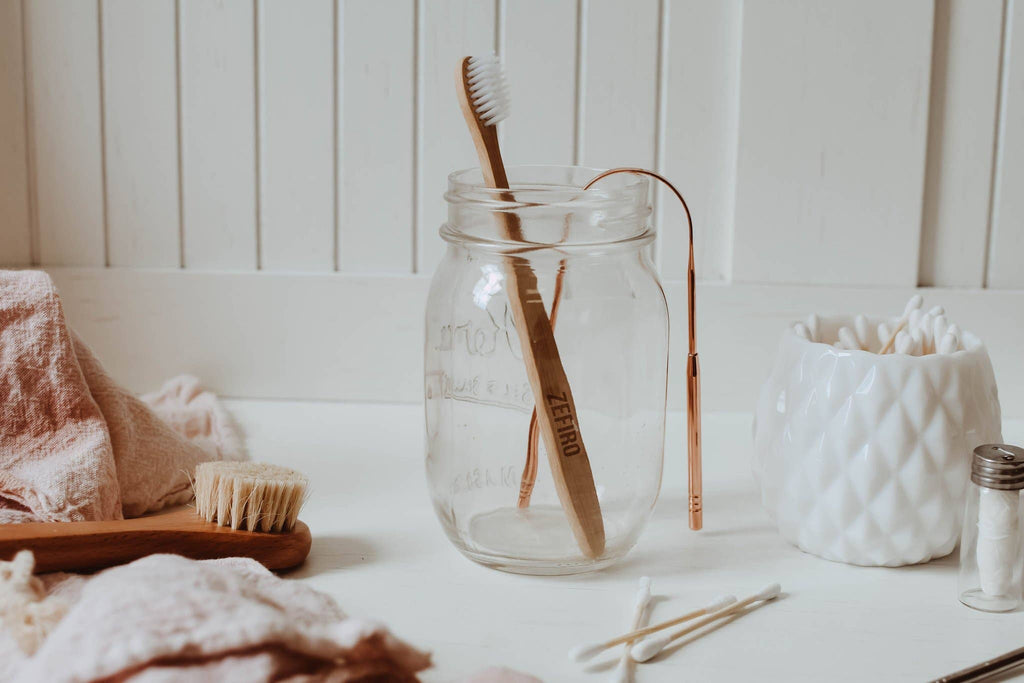 Glass jar with wooden toothbrushes on a bathroom counter