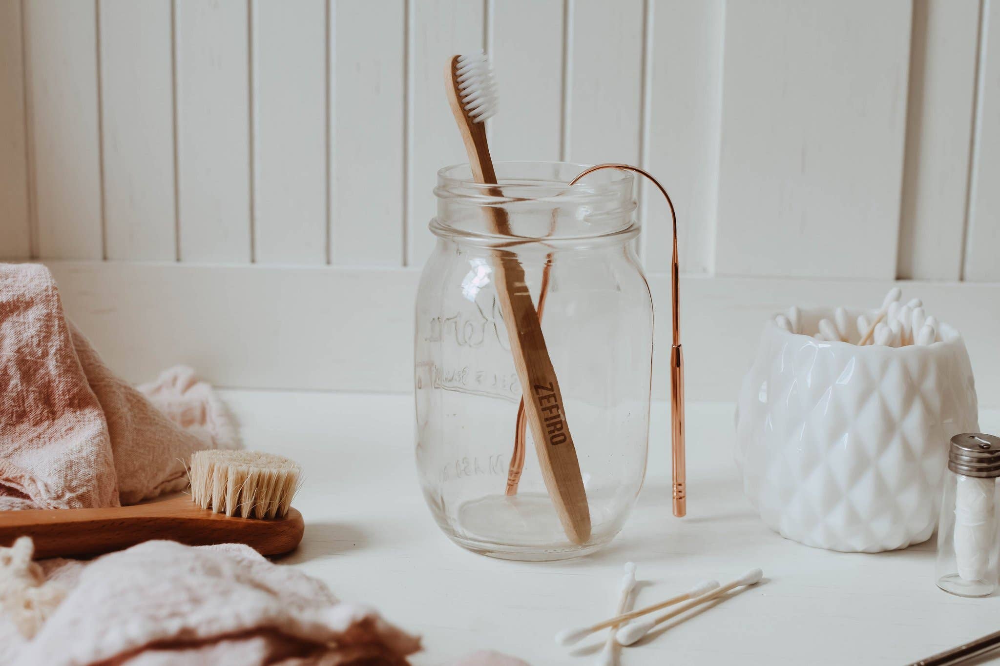 Glass jar with wooden toothbrushes on a bathroom counter