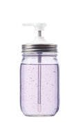 Clear mason jar with a white pump lid on a white background
