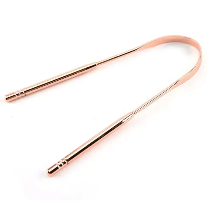 Rose gold tongue scraper on a white background