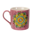 Pink mug with a colorful mandala design on a white background
