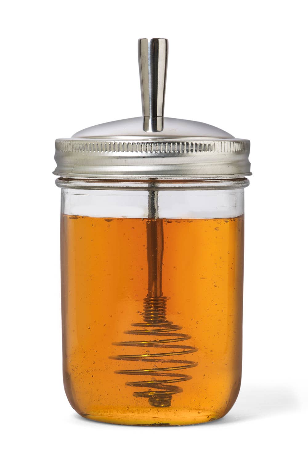 Glass jar with metal lid and handle filled with honey on a white background
