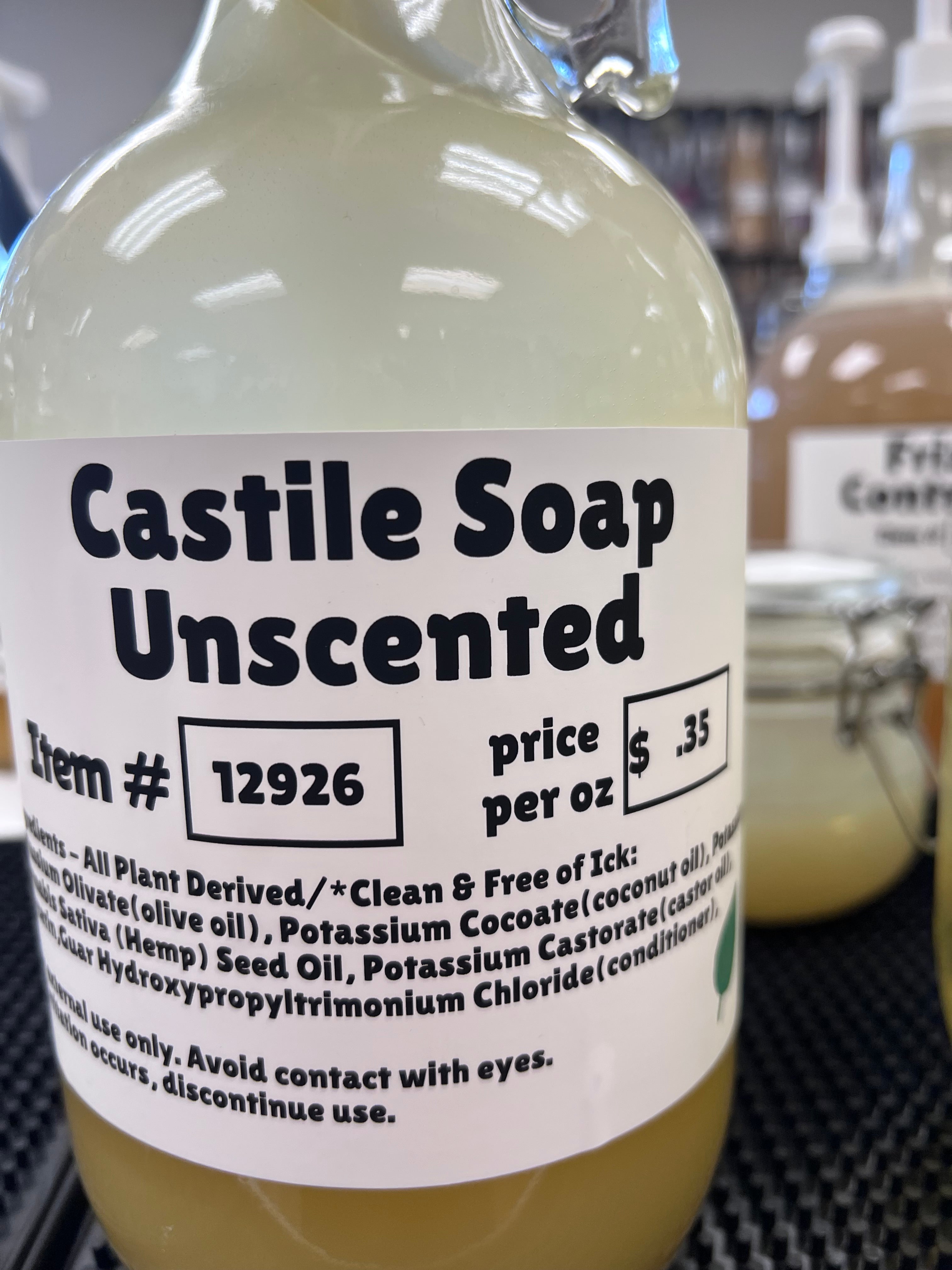 Bottle of Castile Soap Unscented with label showing price and product details.