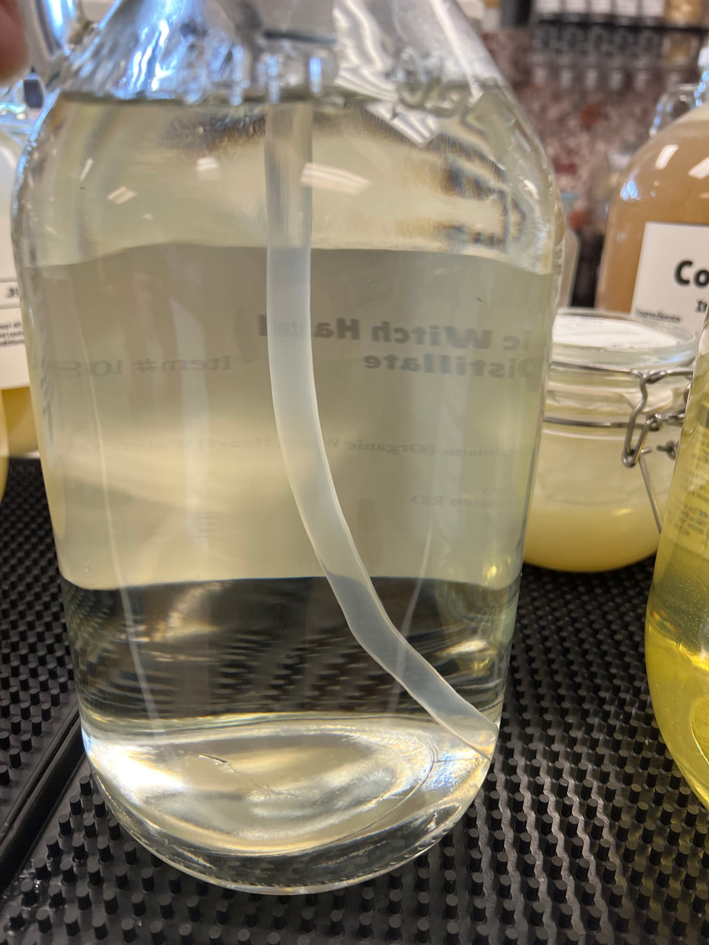 Clear glass container with a label on a textured surface
