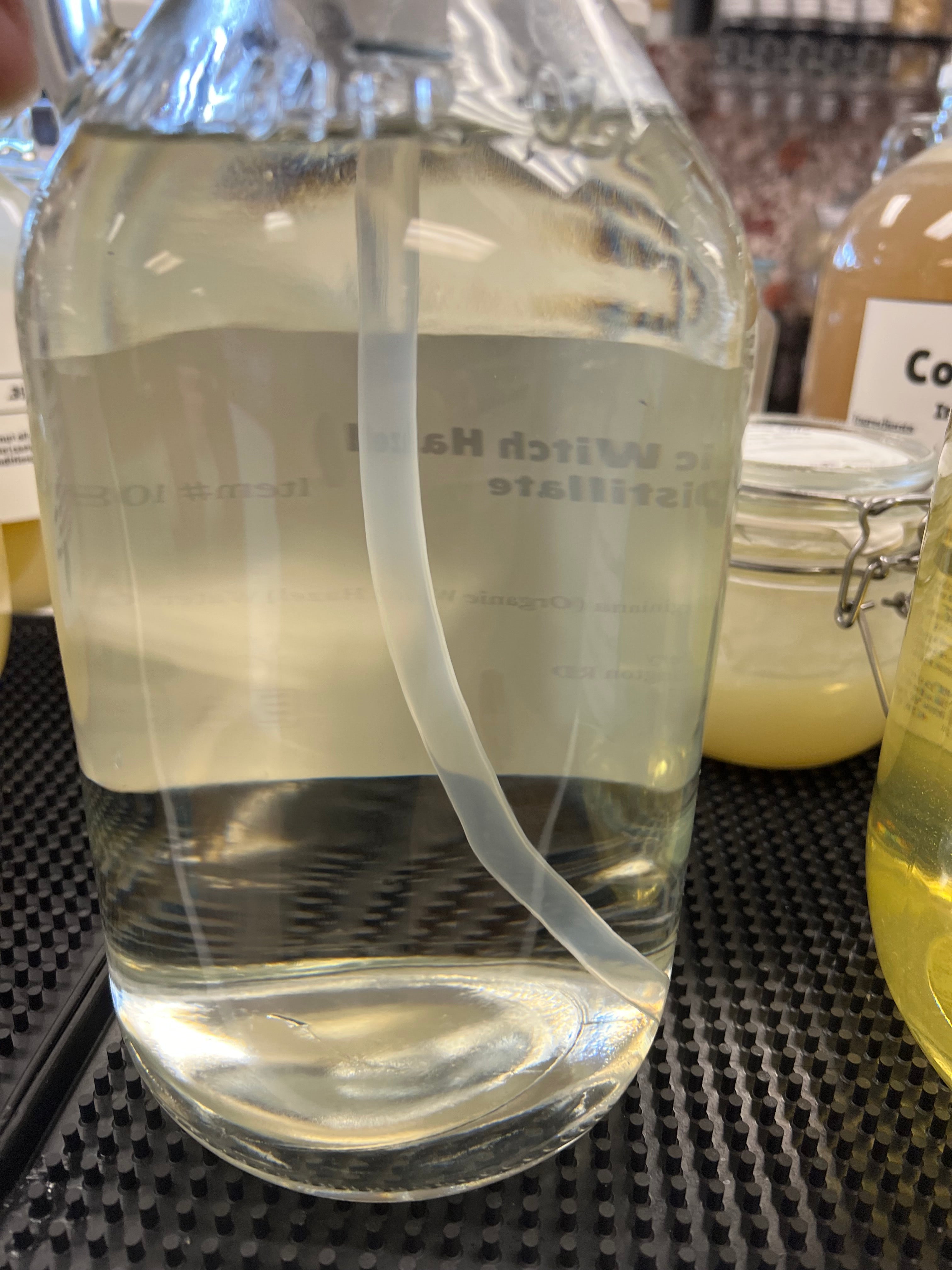 Clear glass container with a label on a textured surface