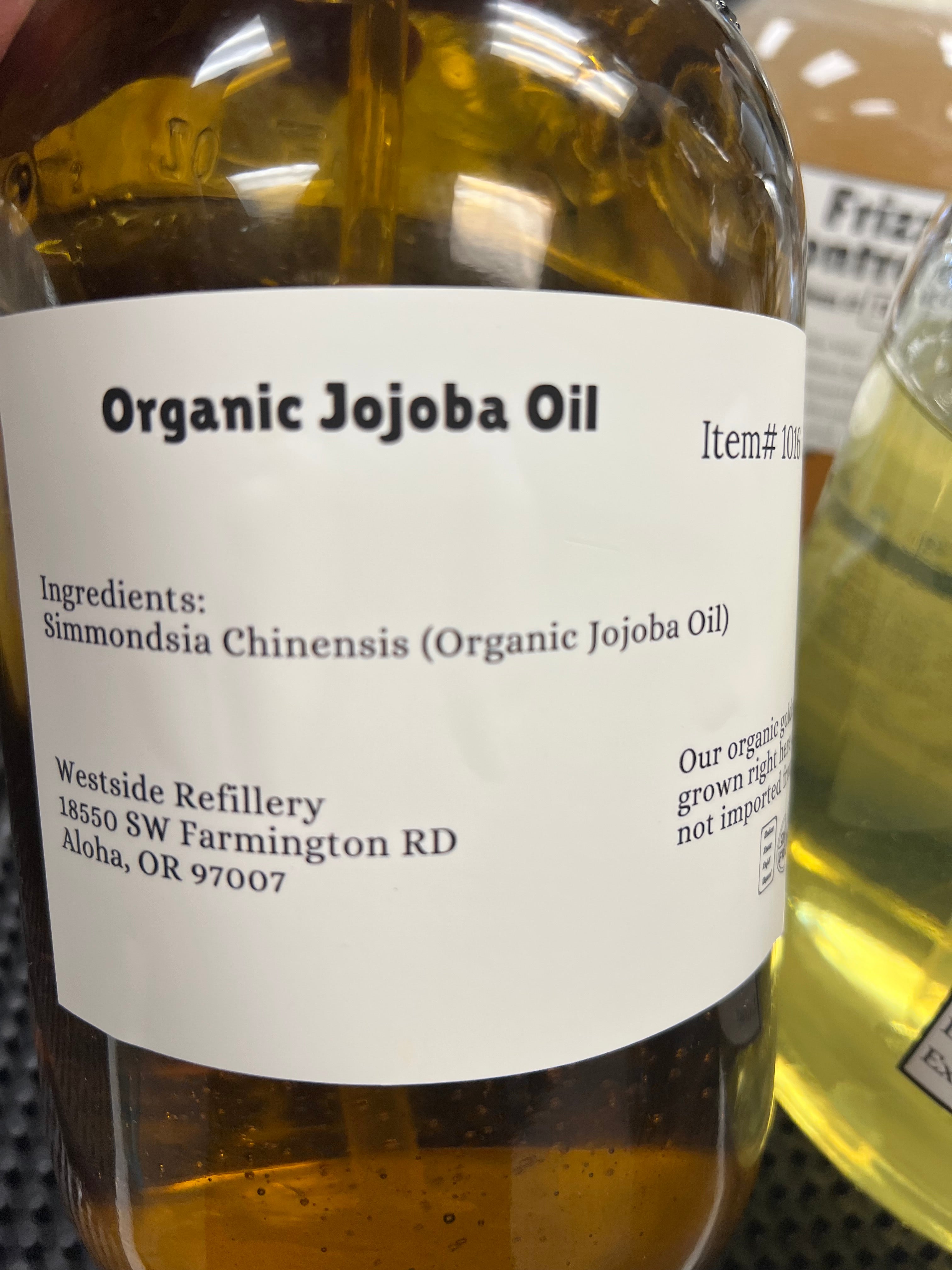Bottle of organic jojoba oil with a label on a textured surface