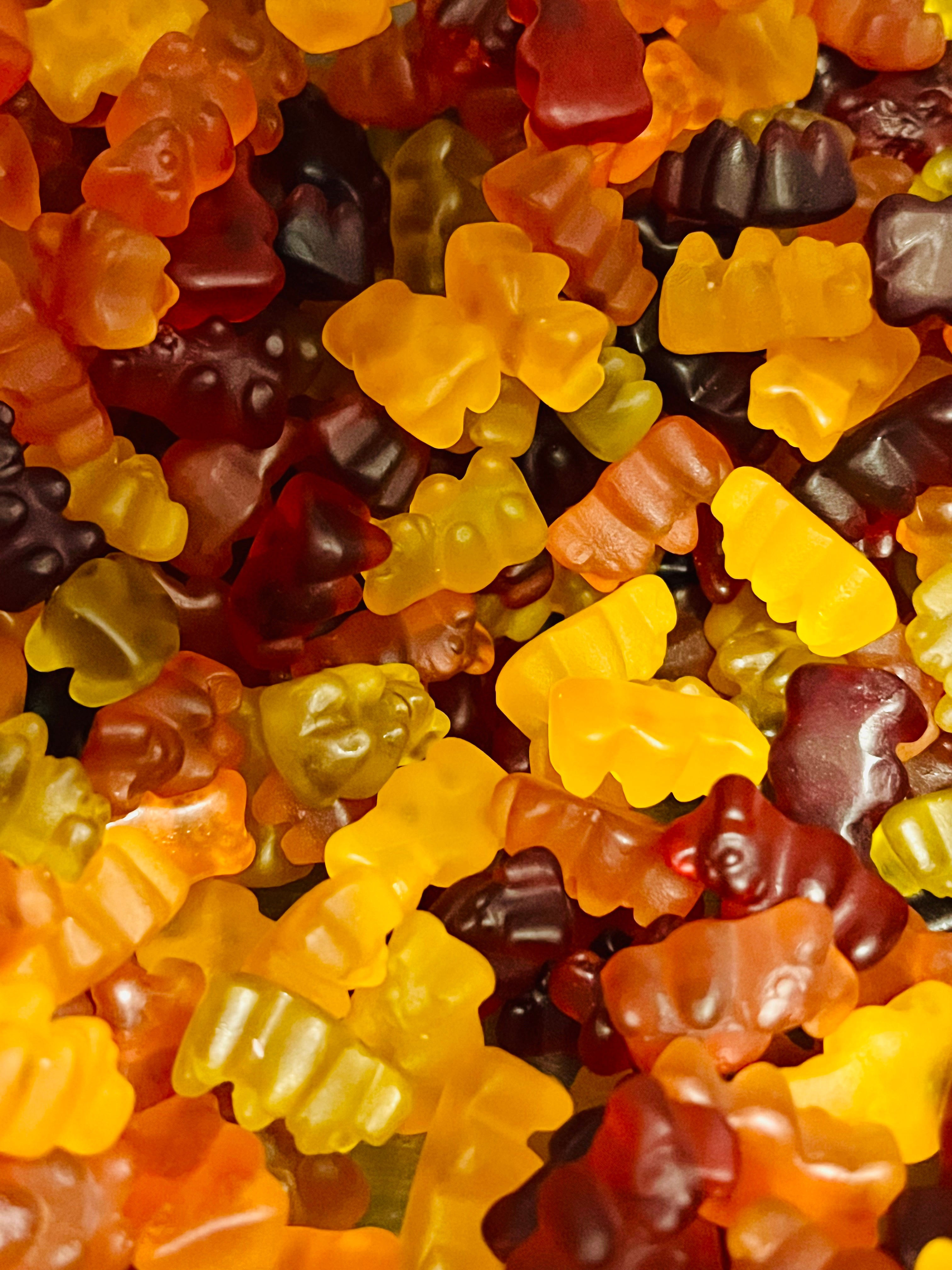 Close-up of colorful gummy bears in various shapes and sizes.