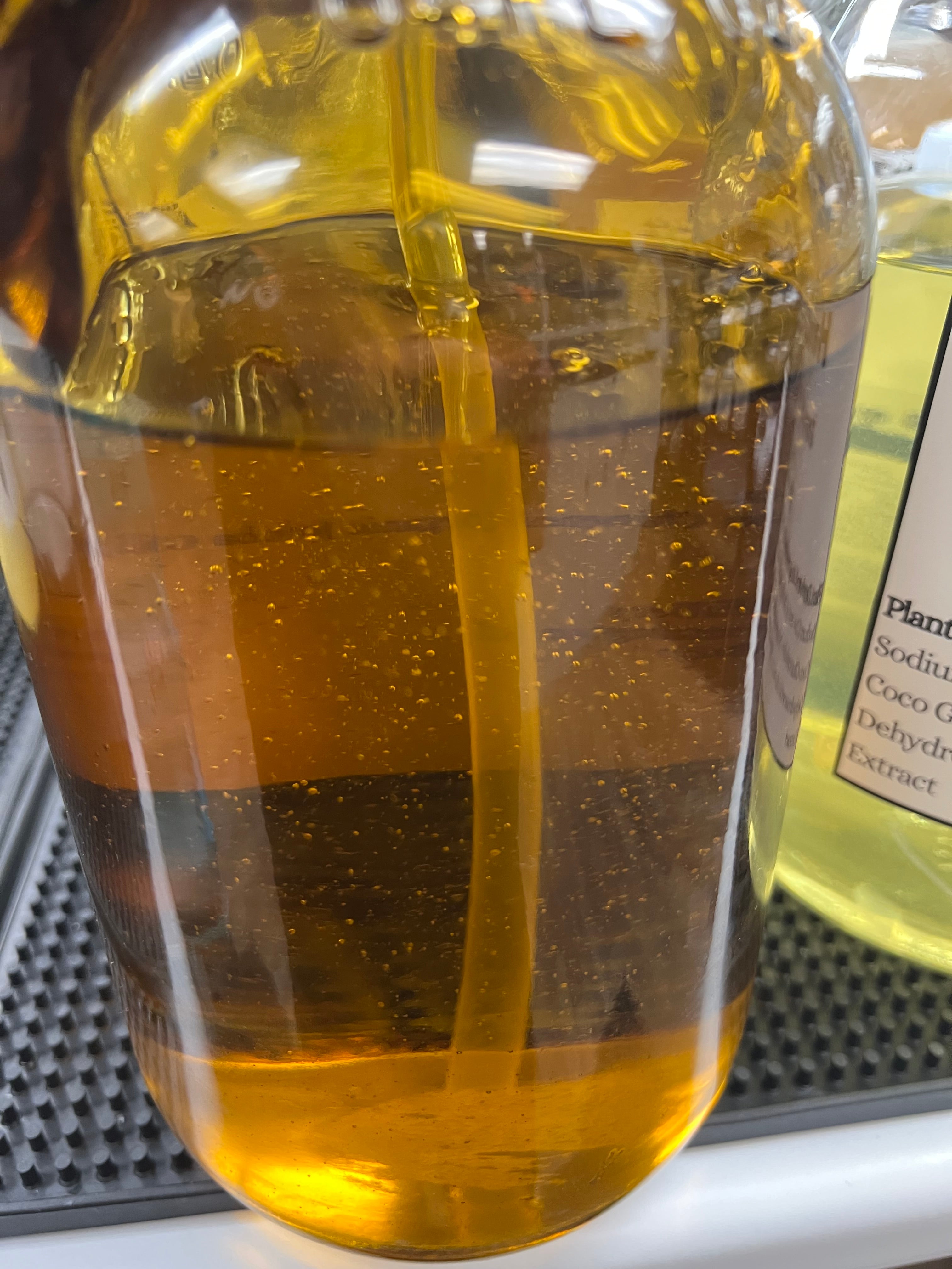 Close-up of a glass bottle with a yellowish oil, blurred background