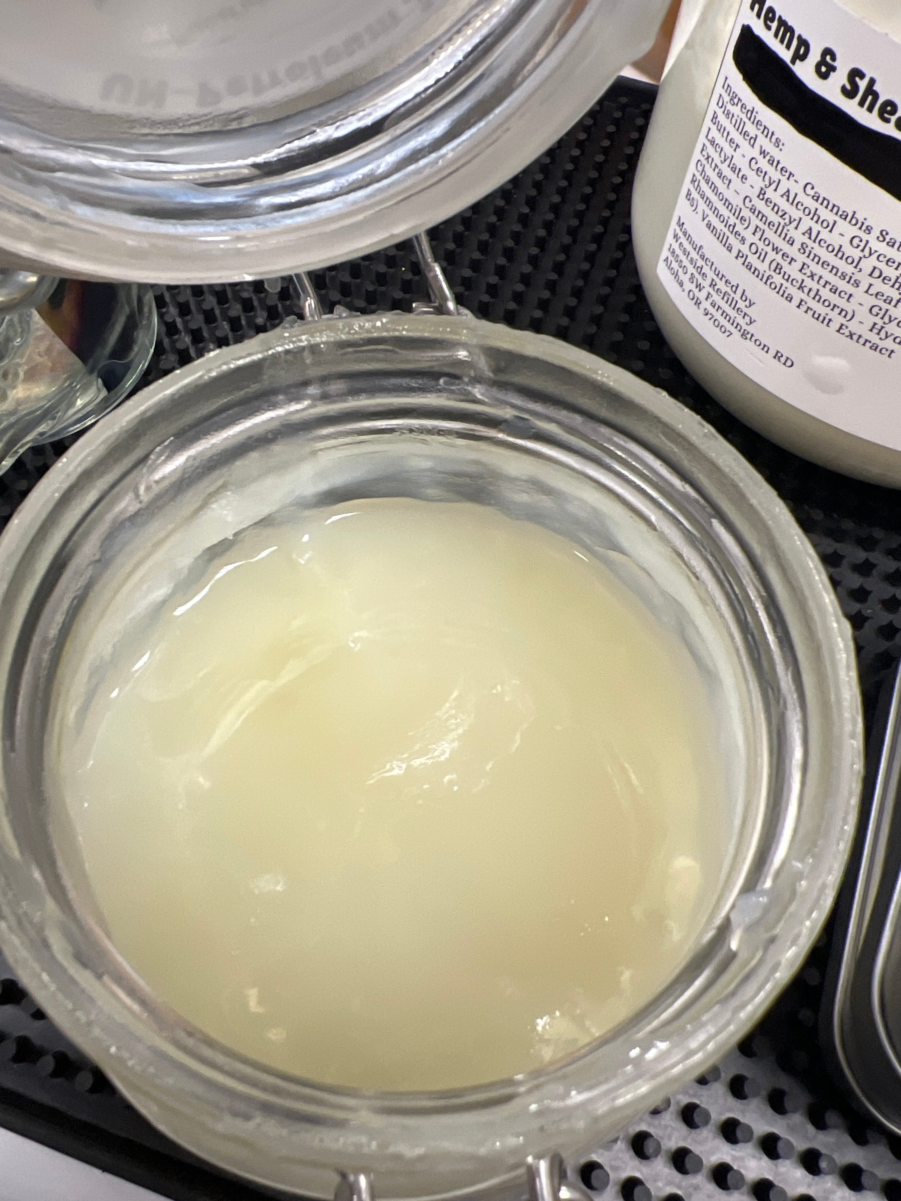 Close-up of a container with a white substance inside, surrounded by other containers.