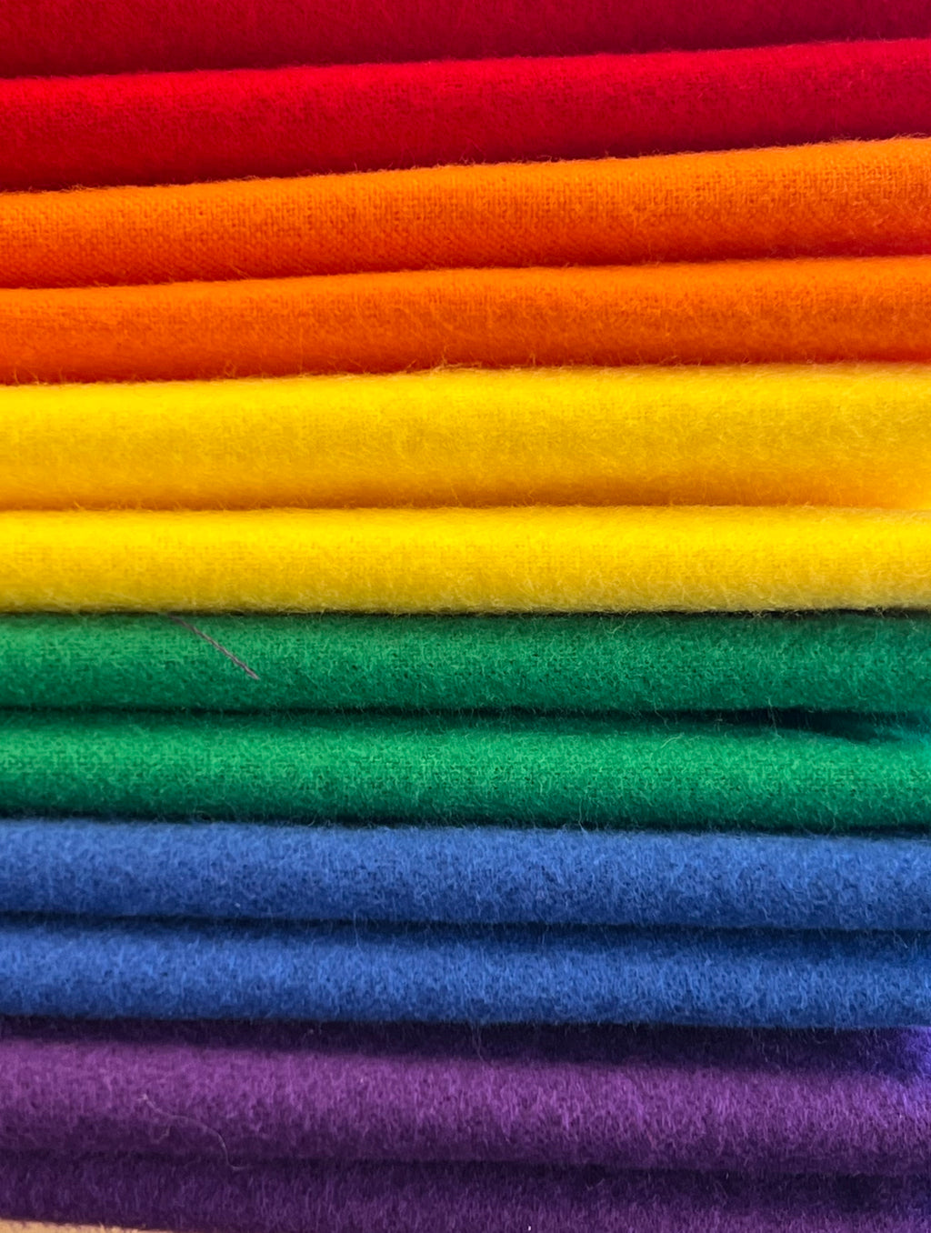 Stack of colorful fabric in a rainbow pattern