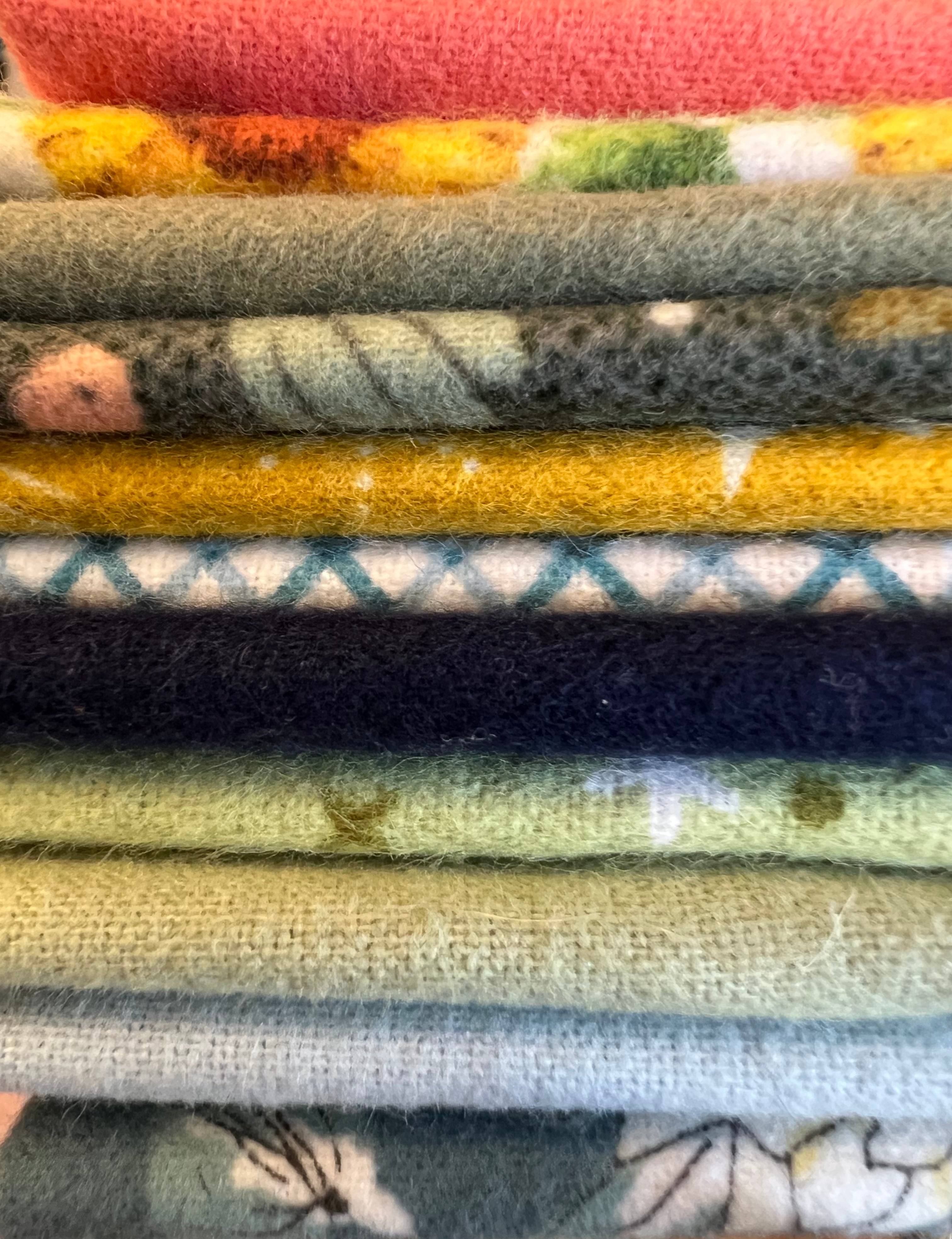 Stack of folded fabric swatches with various patterns and colors.