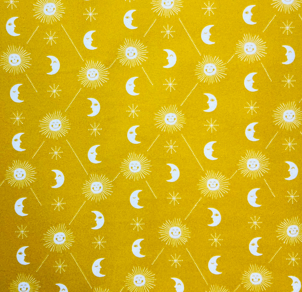 Pattern of suns, moons, and stars on a yellow background