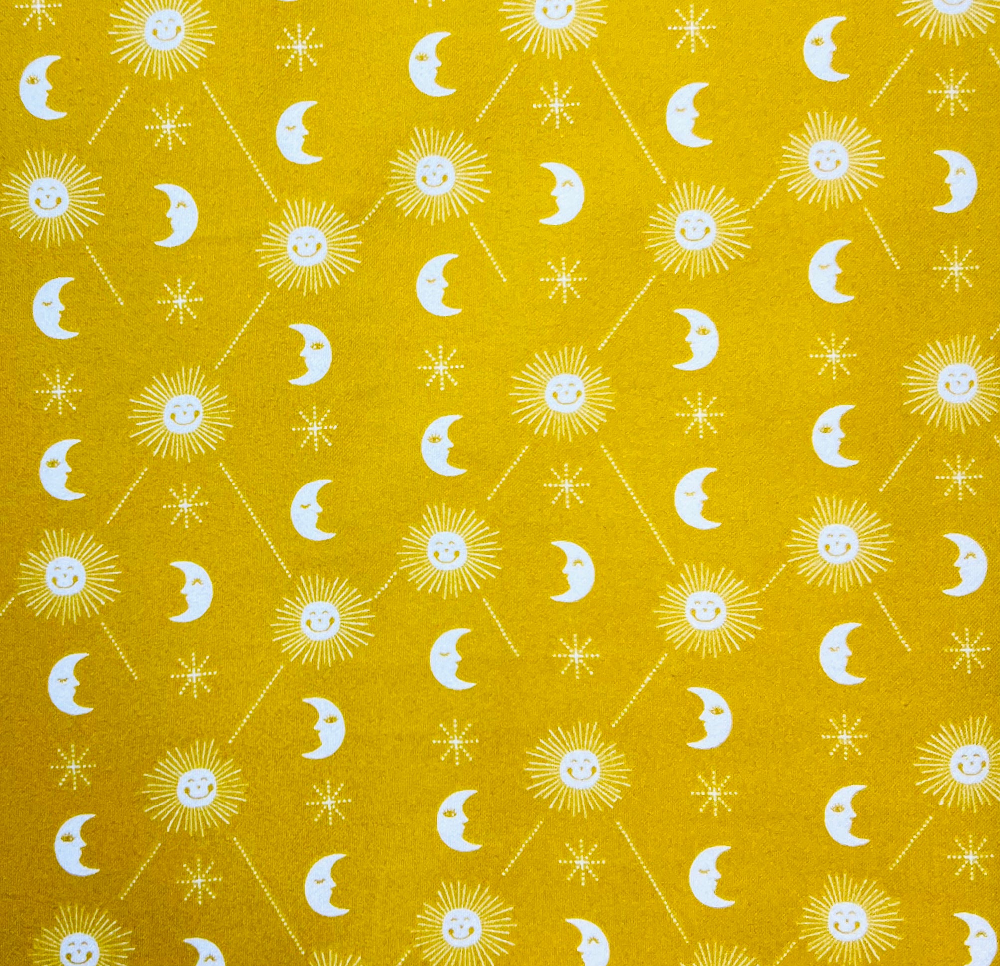 Pattern of suns, moons, and stars on a yellow background