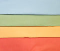 Stack of fabric swatches in light blue, sage green, peach, and coral.