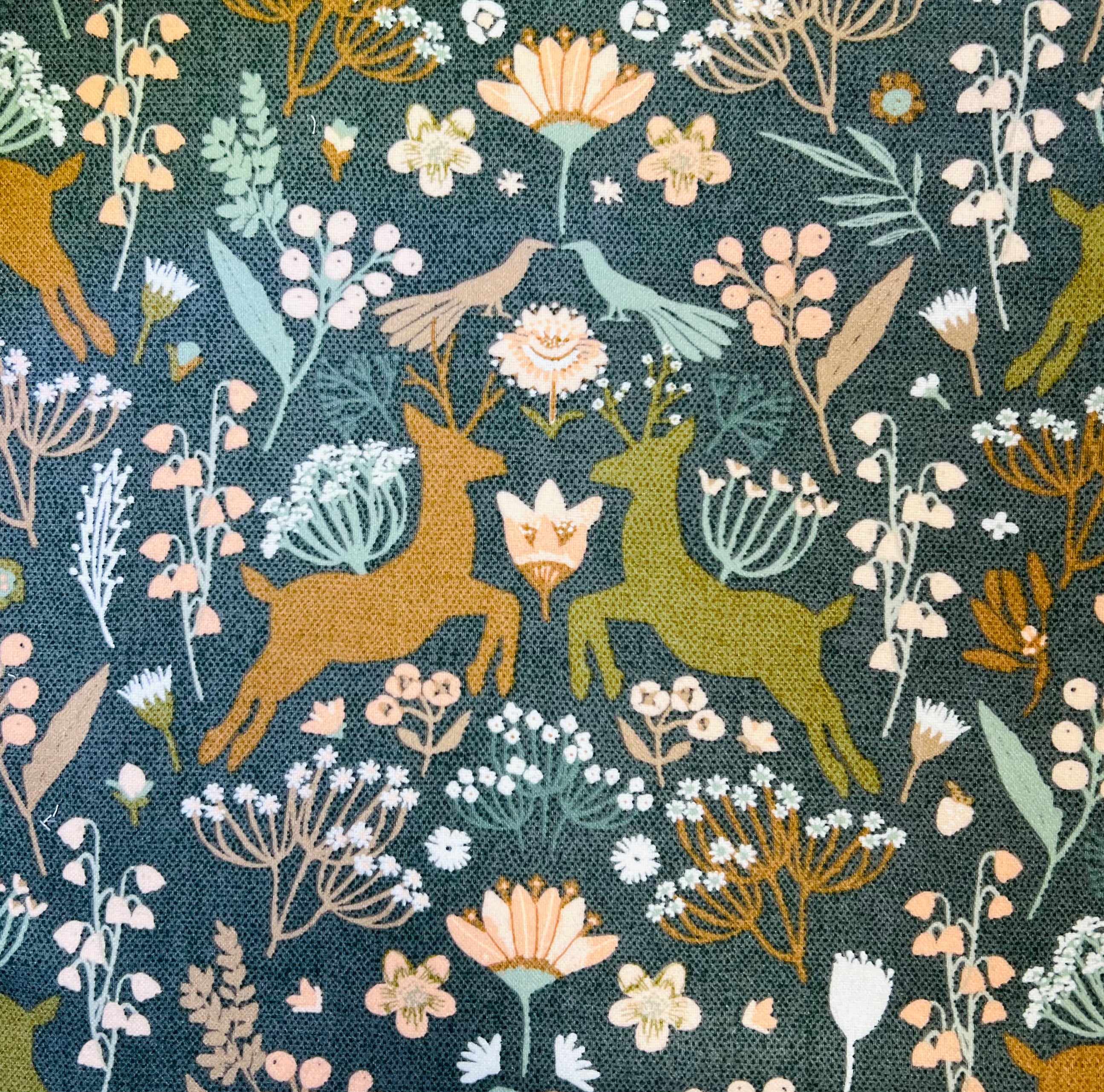 Pattern of deer, flowers, and plants on a dark forest green background