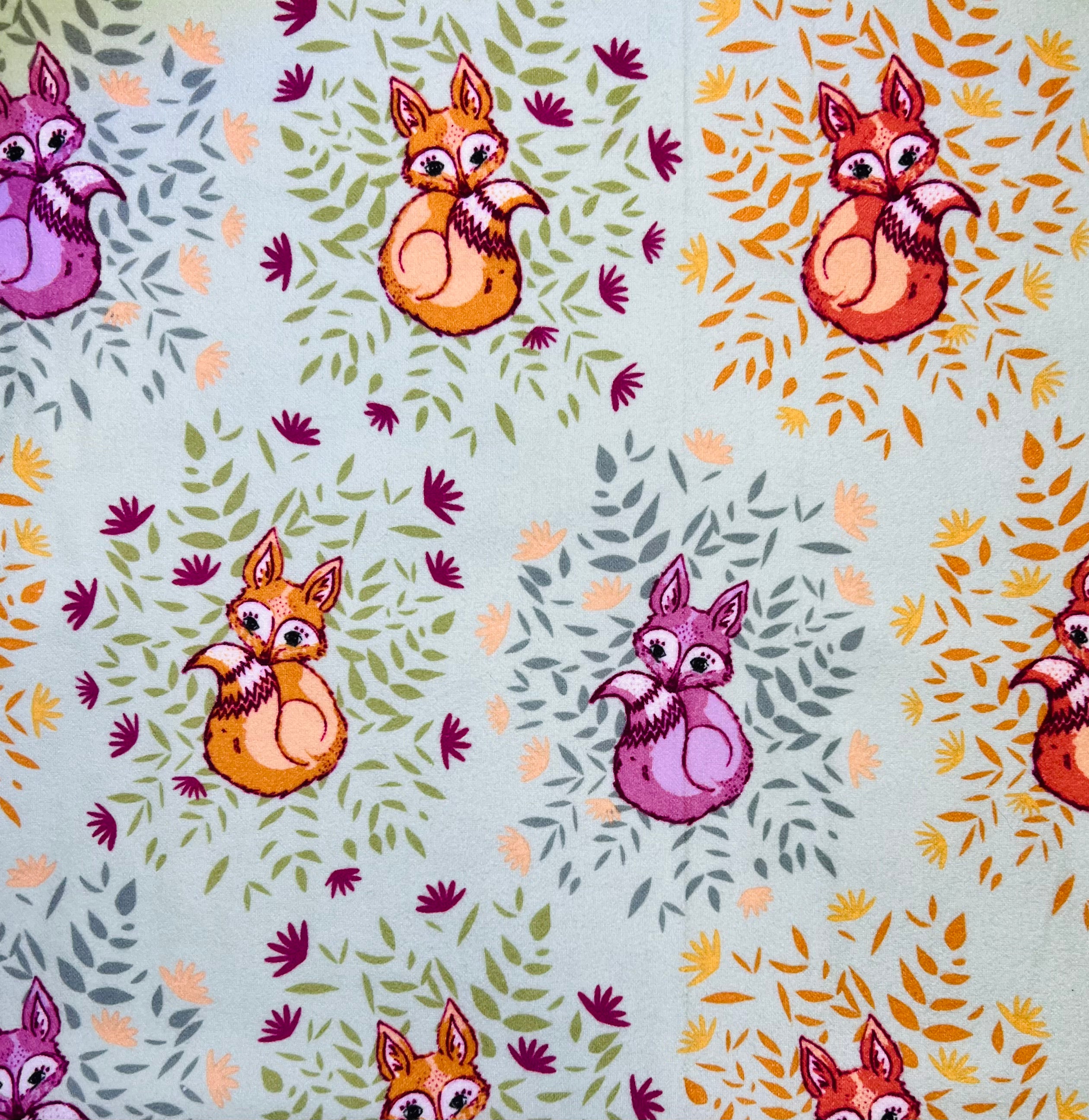 Pattern of cartoon foxes with colorful leaves on a light jade colored background
