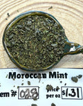 Moroccan mint in a teabag with price and item number information on a wooden surface.