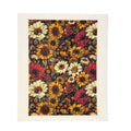 A square textile product, likely a tea towel or small blanket, featuring a dense floral print of sunflowers and roses in yellow, red, cream, and orange on a dark background, finished with a wide cream border.