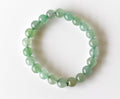 Green beaded bracelet on a white background