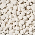 Close-up of a large number of breath mints, small white round tablets