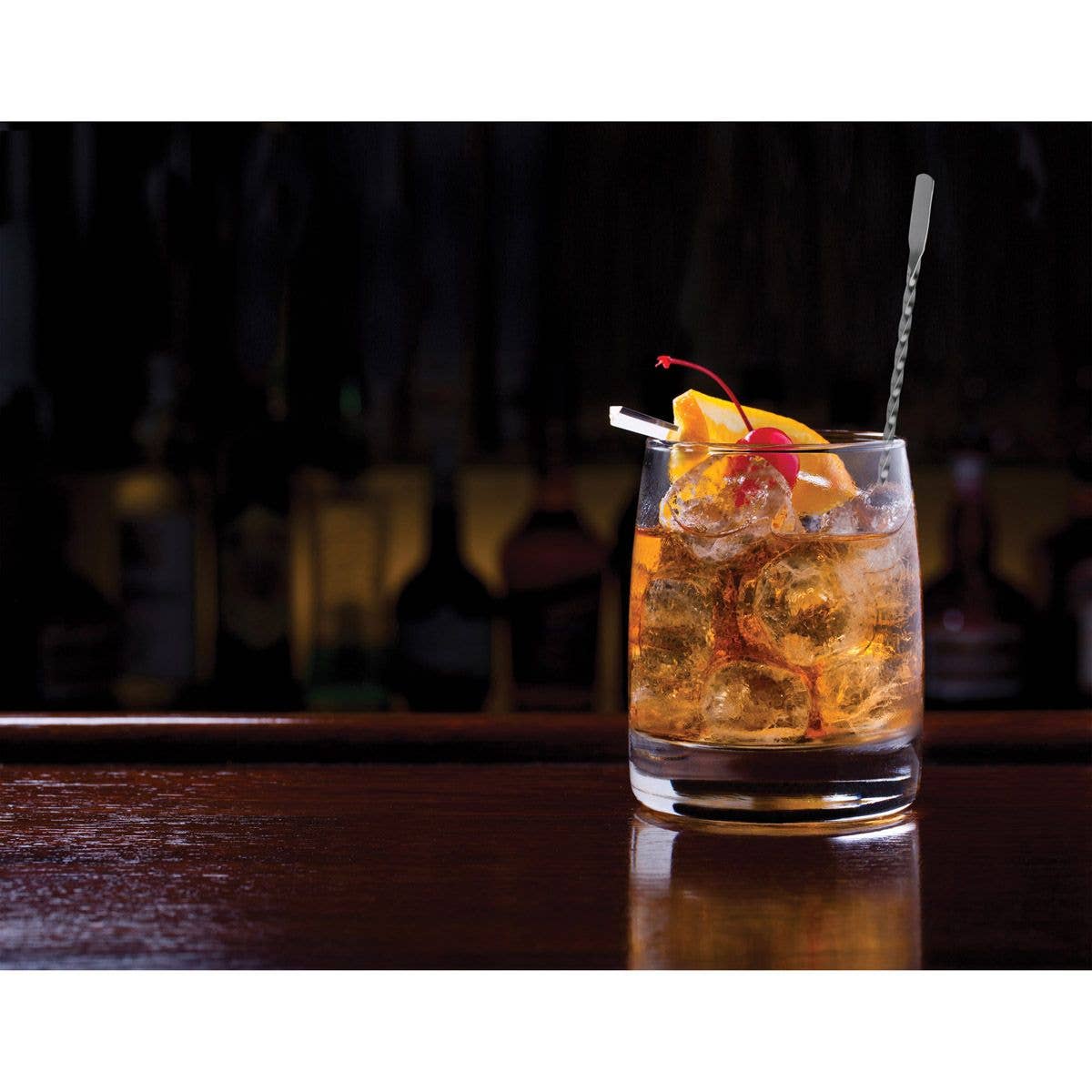 Cocktail with ice and garnish on a bar counter