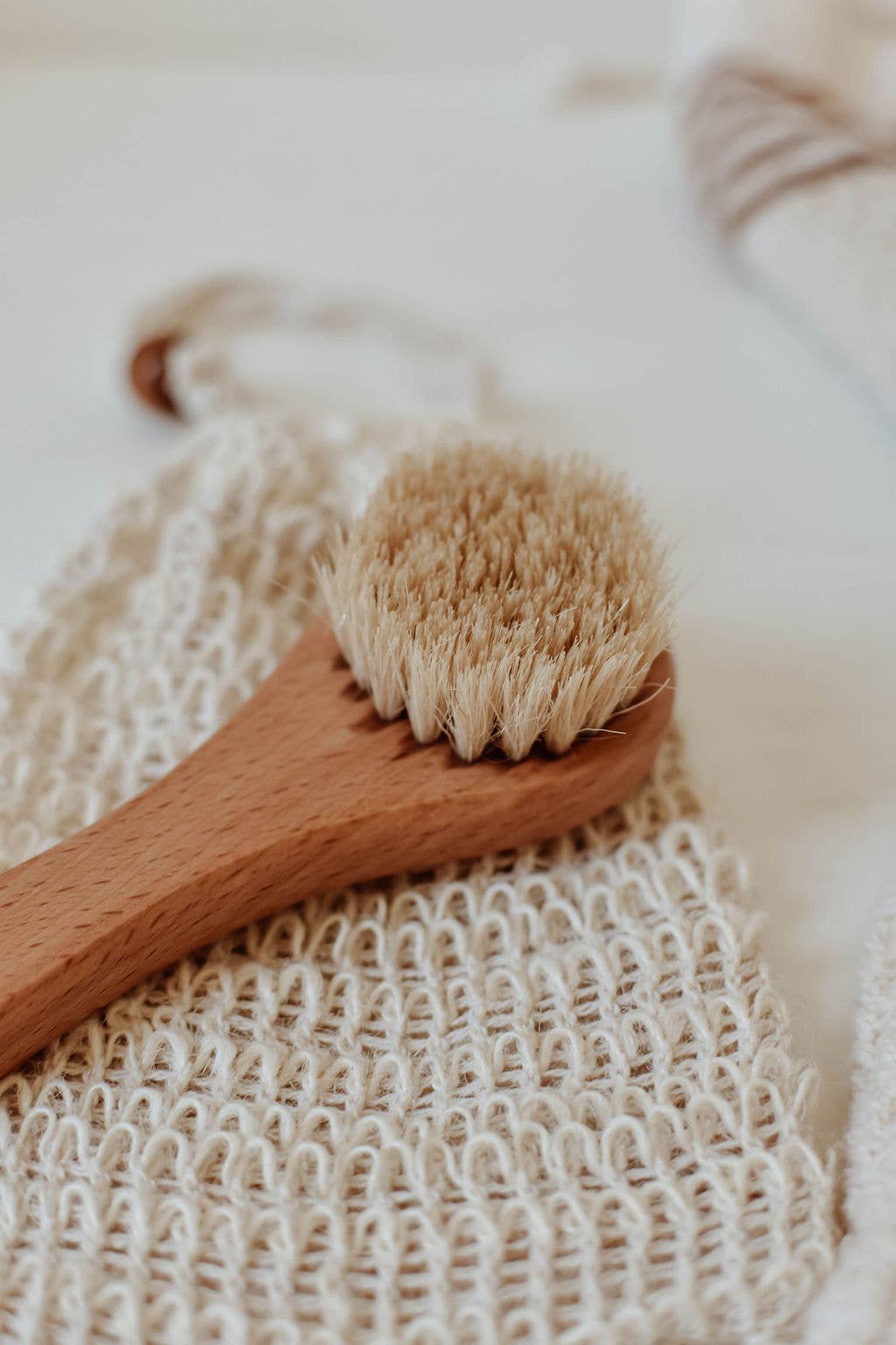 Wooden scrub brush with natural bristles on a textured surface