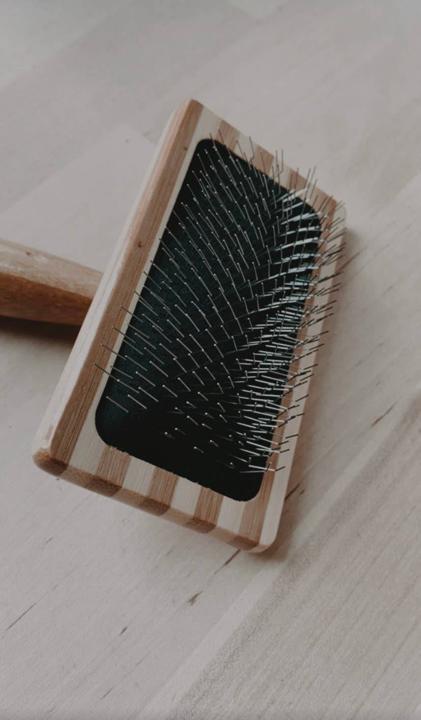 Wooden brush with bristles on a light wooden surface