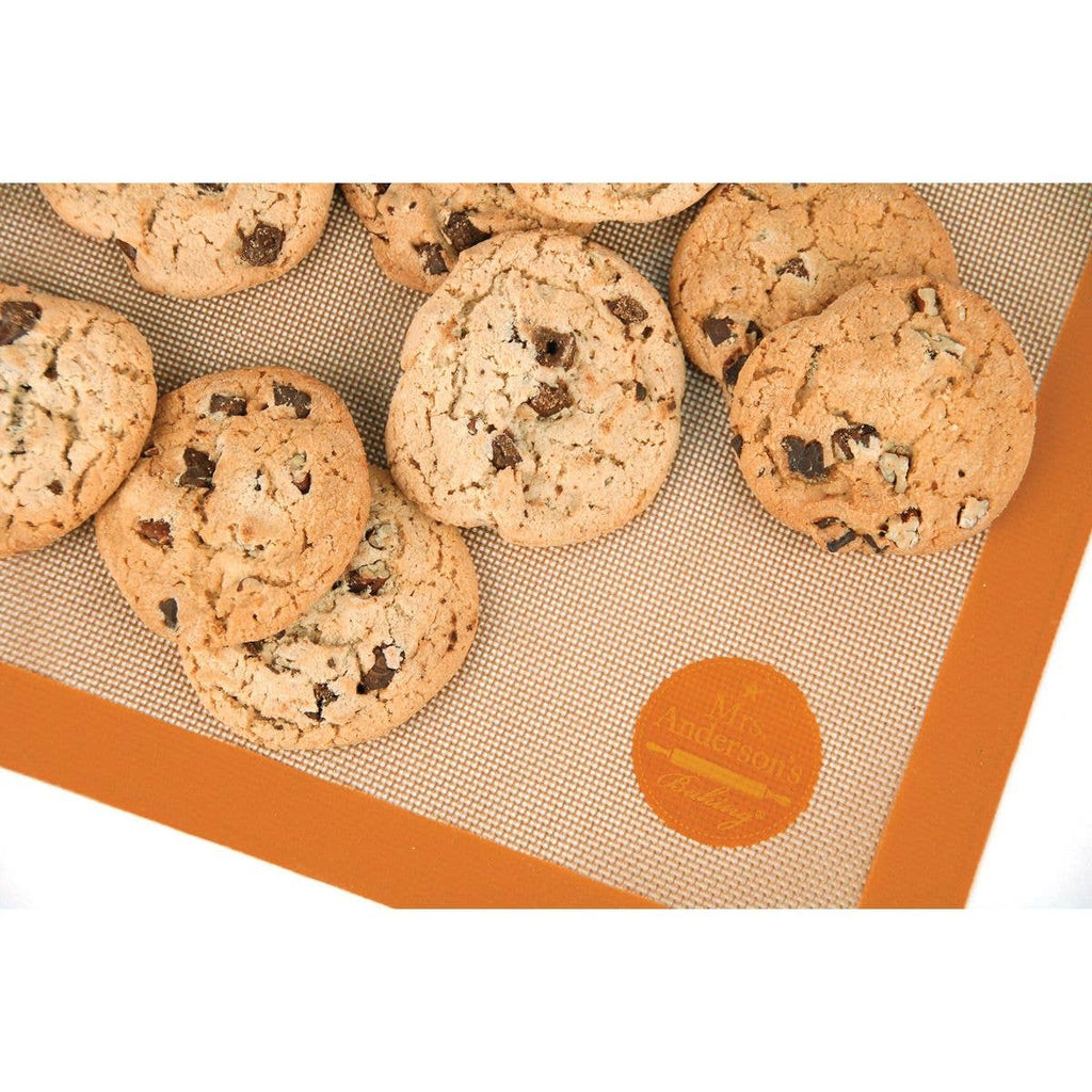Chocolate chip cookies on a silicone baking mat with a brand logo.