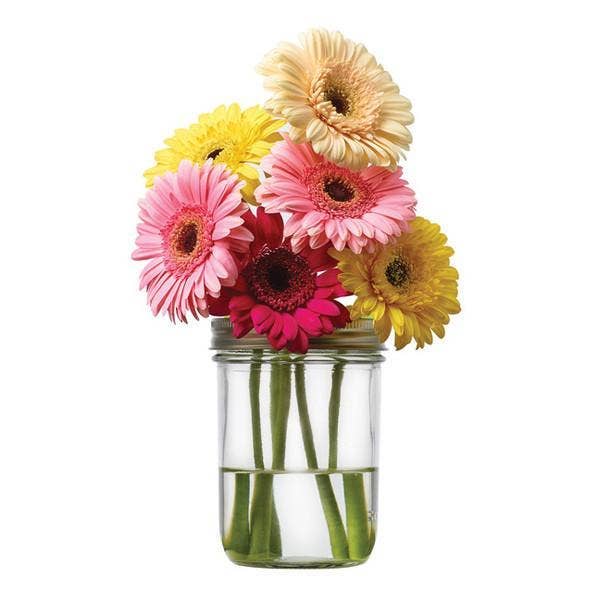 Clear glass jar with colorful flowers on a white background