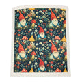 A square fabric item, likely a tea towel or napkin, featuring a whimsical garden gnome pattern on a dark navy background. The pattern includes red-hatted gnomes, red and yellow mushrooms, and small houses among white and yellow flowers.