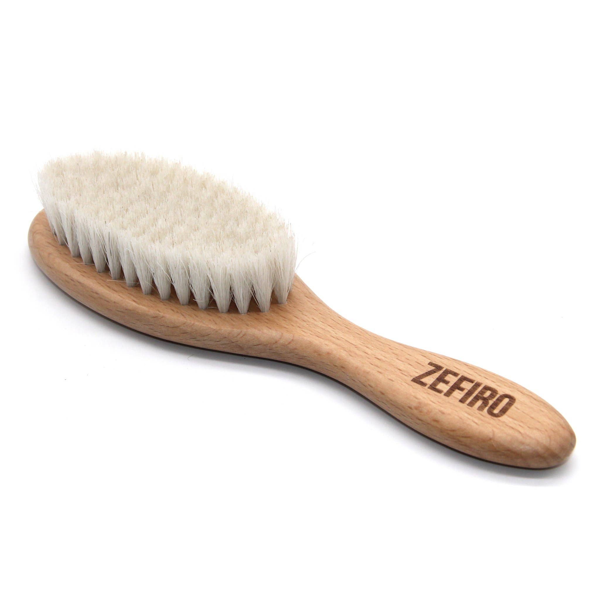 Wooden brush with white bristles on a white background, branded 'Zefiro'.