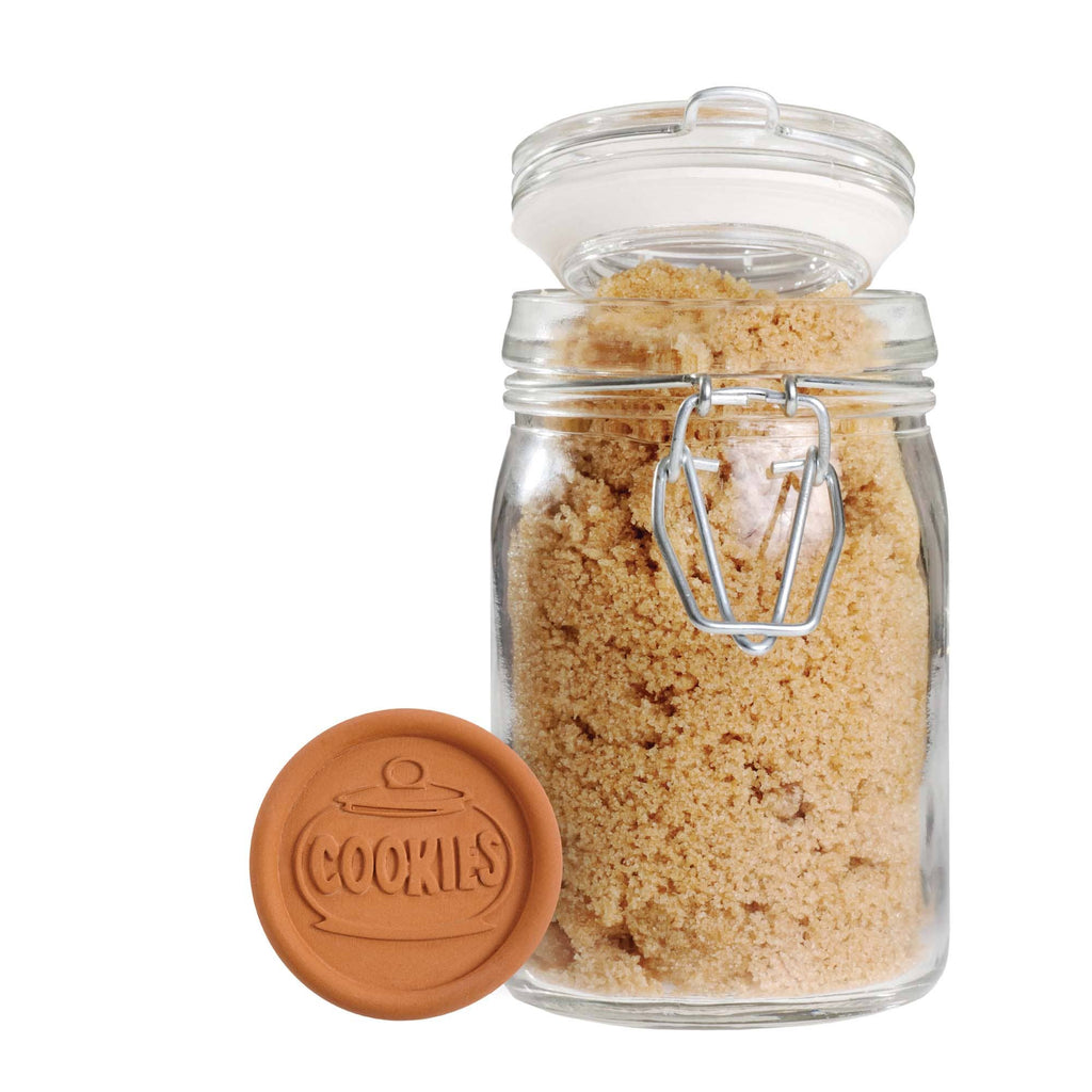 Glass jar with brown sugar and a matching lid on a white background