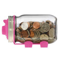 Glass jar with pink lid and base filled with coins on a white background