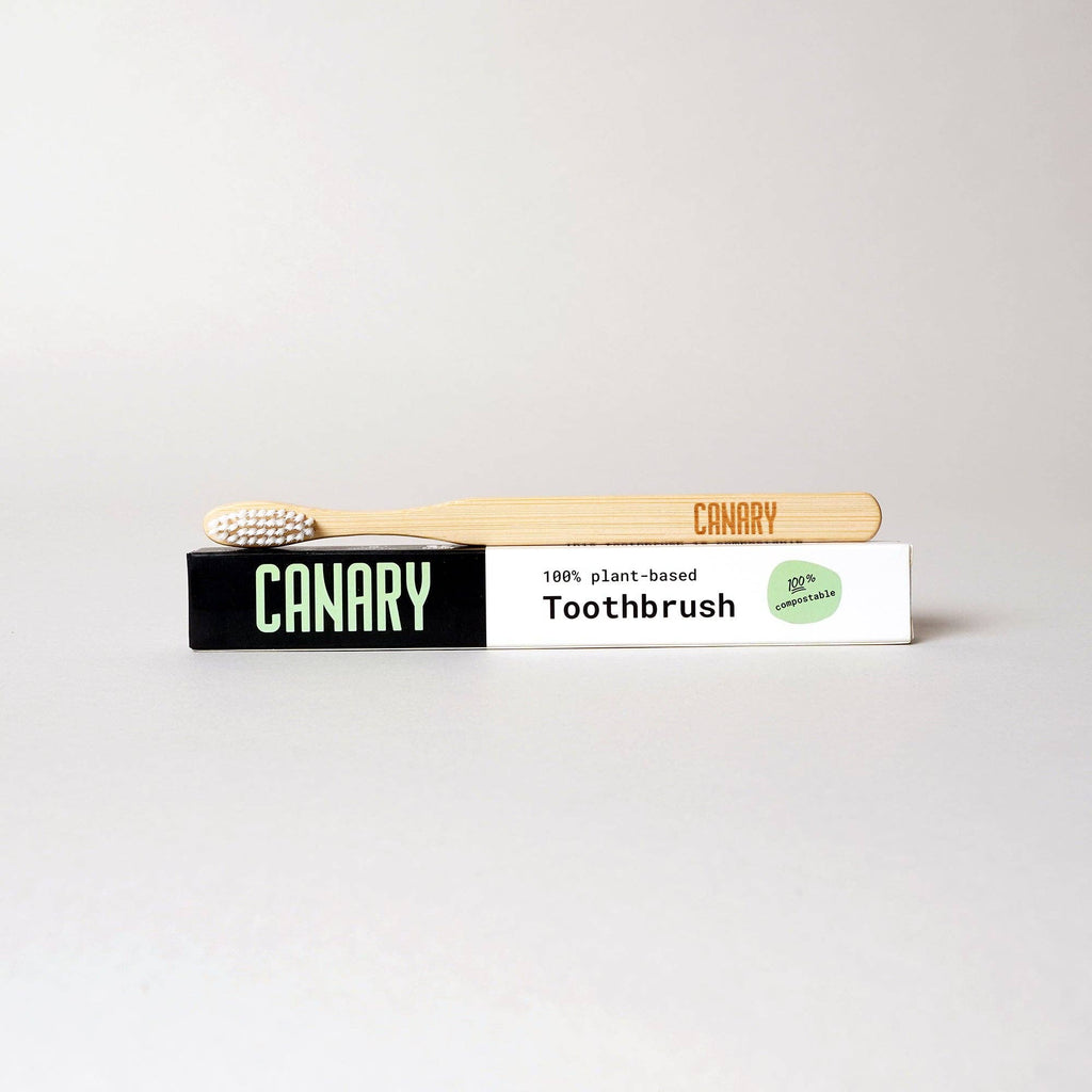 Canary toothbrush with packaging on a light gray background